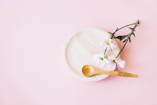 Деревянная тарелка с ложкой и цветком