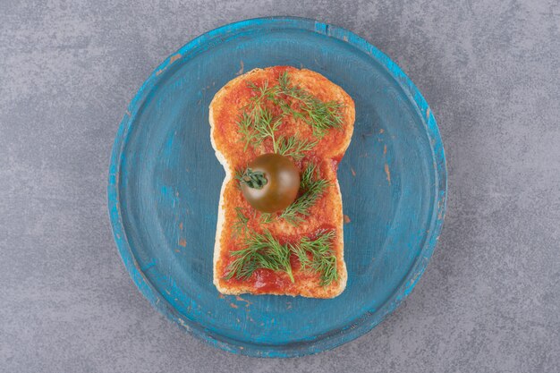 A wooden plate with toast on a marble surface