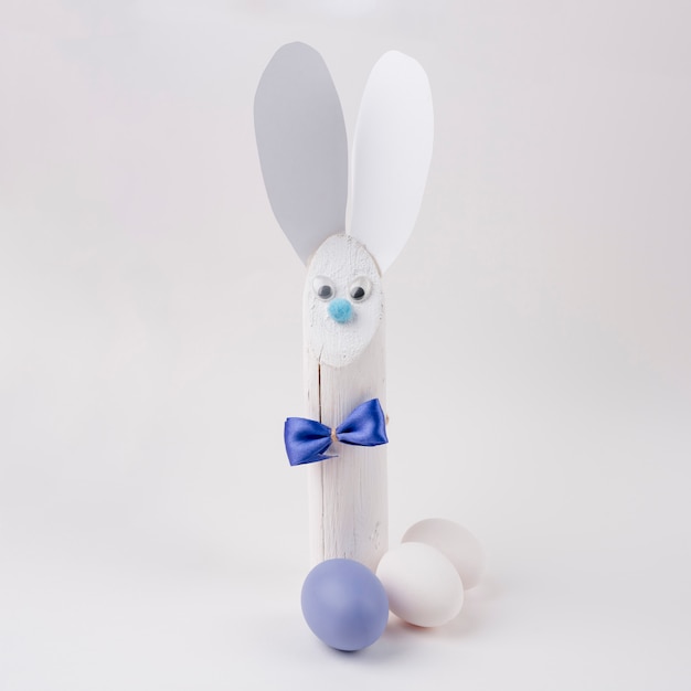 Wooden rabbit with paper ears and Easter eggs