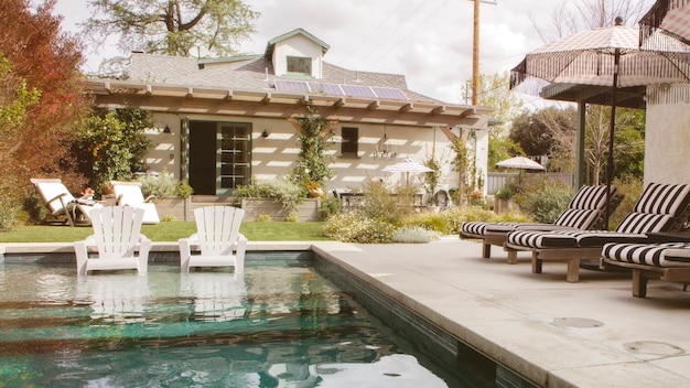 Wooden seats by a pool with parasols