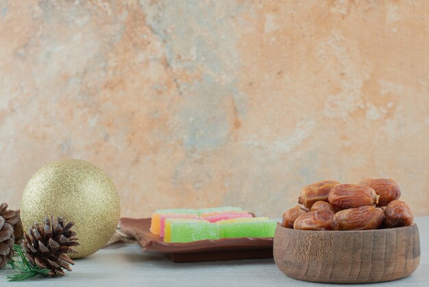 A wooden small bowl full of dried fruits and marmalade on marble background. High quality photo