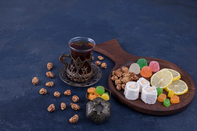 Wooden snack platter with marmelades and a glass of tea