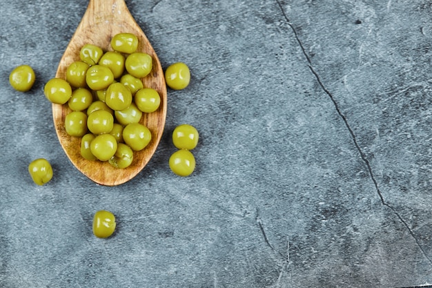 Free photo a wooden spoon of boiled green peas.