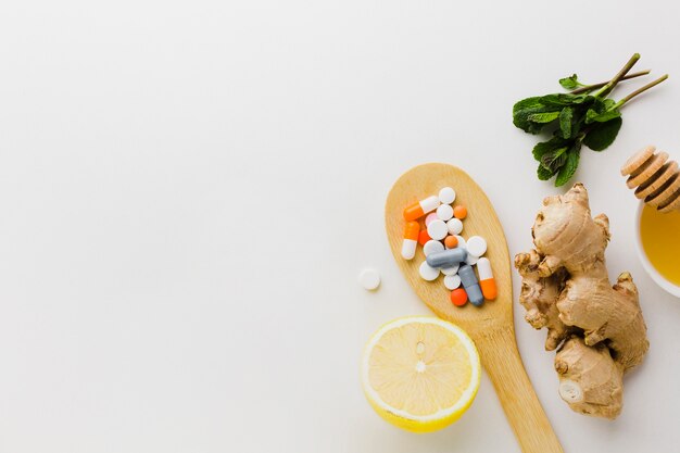 Wooden spoon filled with pills and natural treatment