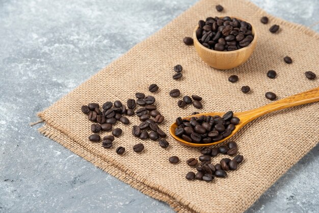 黄麻布にローストしたコーヒー豆がたっぷり入った木のスプーン。