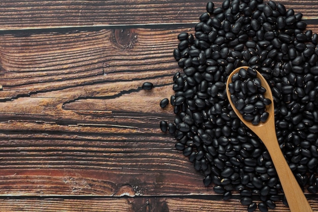 wooden spoon place on floor that full of black beans