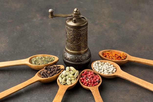 Free photo wooden spoon with spices and grinder