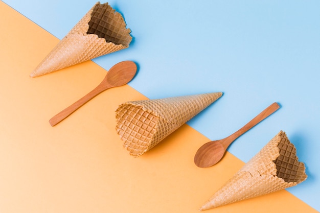 Foto gratuita cucchiai e coni di gelato di legno sulla tavola