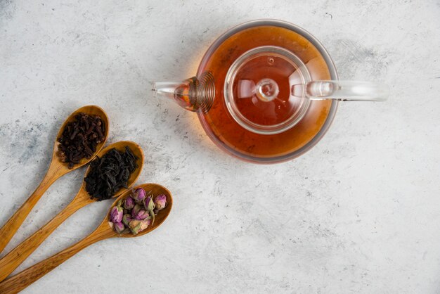 Wooden spoons with dried roses, loose teas and cloves.