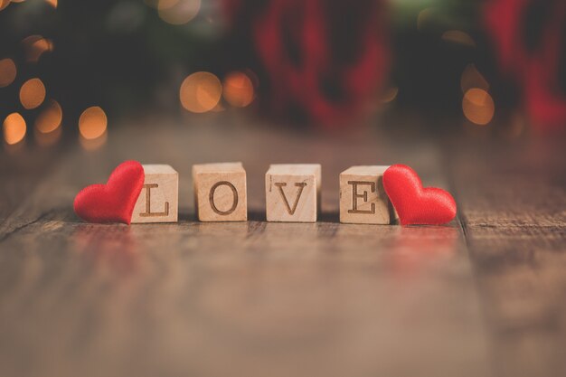 Wooden squares with [LOVE] written on them with bokeh lights on the backgrounds