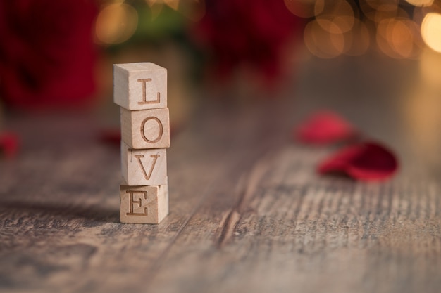 Wooden squares with [LOVE] written on them with bokeh lights on the backgrounds