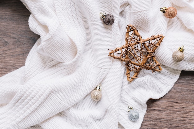 Wooden star with shiny baubles on table 