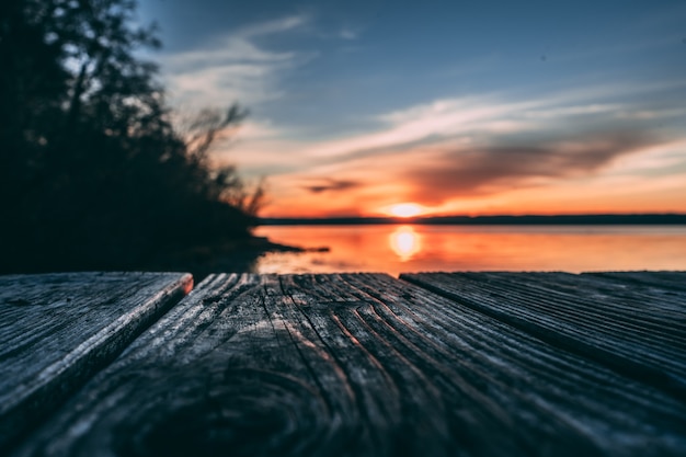 Foto gratuita superficie in legno su sfondo spiaggia al tramonto