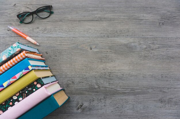 Деревянная поверхность с книгами, очками и ручкой
