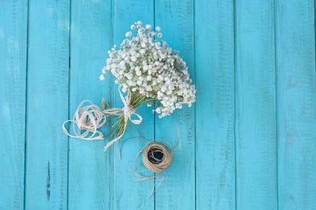 Free photo wooden surface with bouquet and rope