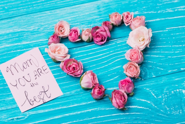 Wooden surface with card and floral heart for mother's day