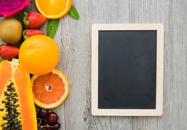 Wooden surface with decorative slate and summer fruits