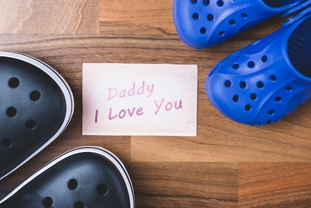 Wooden surface with note and shoes for father's day