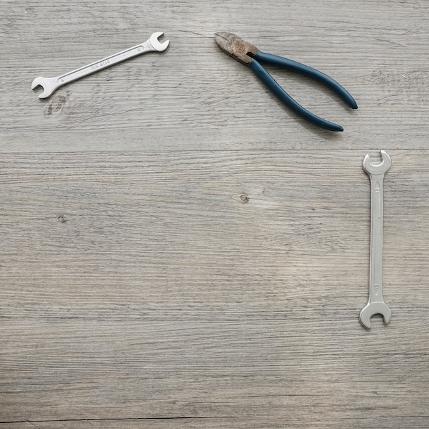 Wooden surface with pliers and wrenches