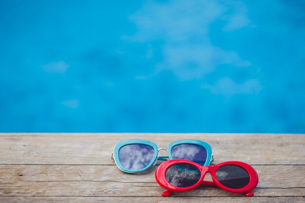 Wooden surface with red and blue sunglasses