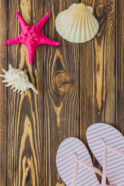 Wooden surface with seashells and flip flops