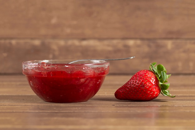 Superficie di legno con fragole e marmellata di fragole