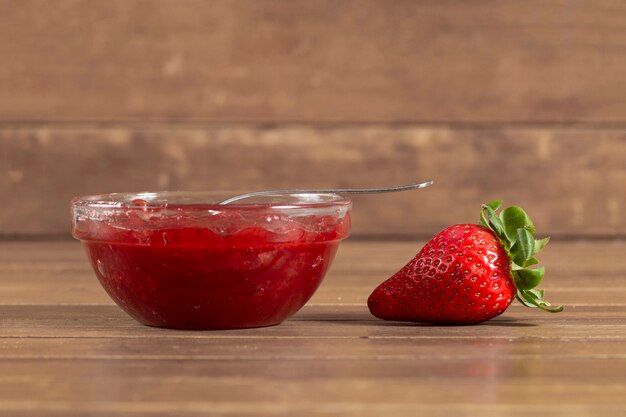 Wooden surface with strawberry and strawberry jam