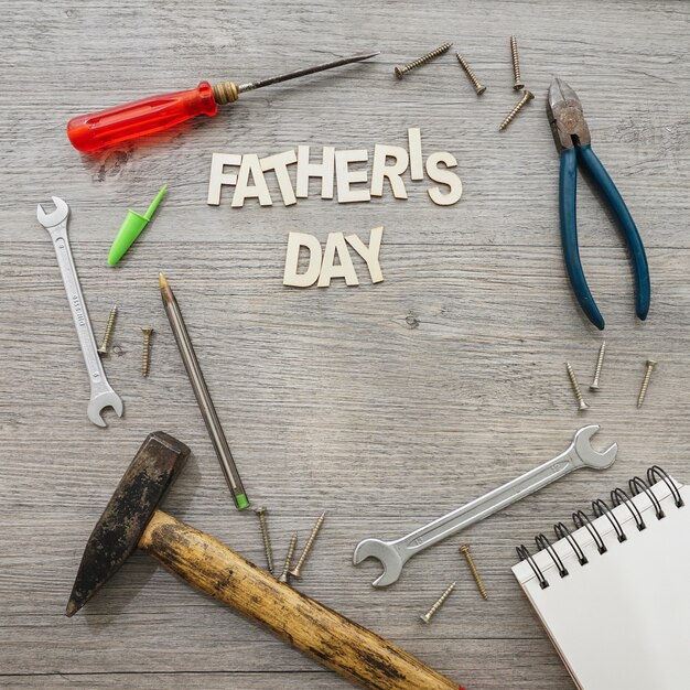 Wooden surface with tools and notebook for father's day