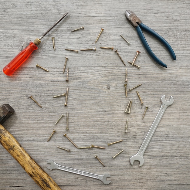 Foto gratuita superficie in legno con utensili e telaio a vite