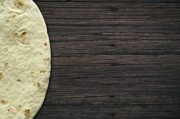 Free photo wooden surface with a tortilla bread on the side