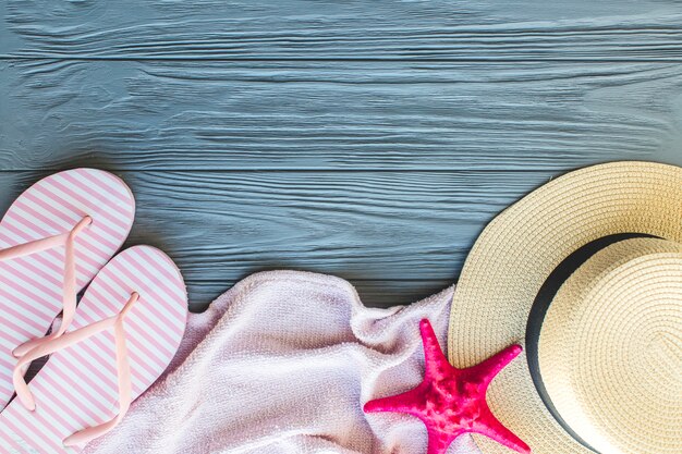 Wooden surface with towel, flip flops and hat