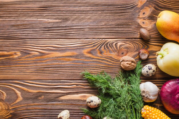 Wooden surface with vegetables on right