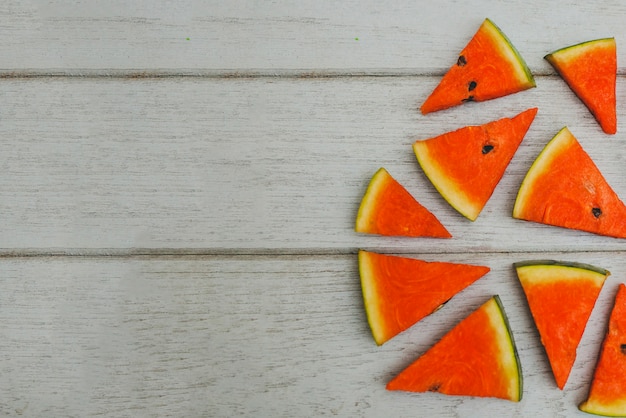 Wooden surface with watermelon pieces and blank space