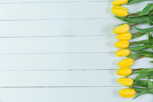 Wooden surface with yellow tulips