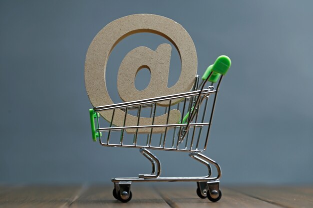 wooden symbol @ in shopping cart, Online shopping concept