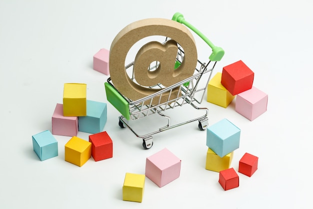 Free photo wooden symbol @ in shopping cart, online shopping concept