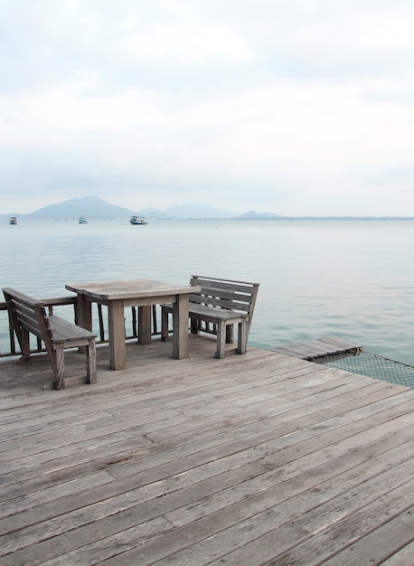 열 대 해변 휴양지에 나무 테이블과 의자