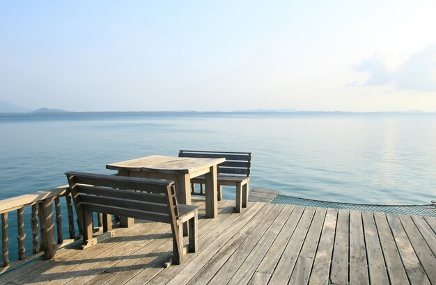 열 대 해변 휴양지에 나무 테이블과 의자