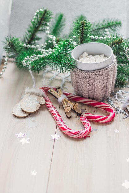 Деревянный стол, покрытый конфетами, зефиром и рождественскими украшениями под огнями