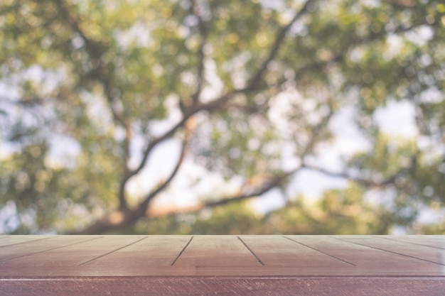 Wooden table in front of blurred tree