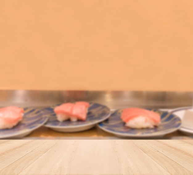 Free photo wooden table top with blurred sushi background