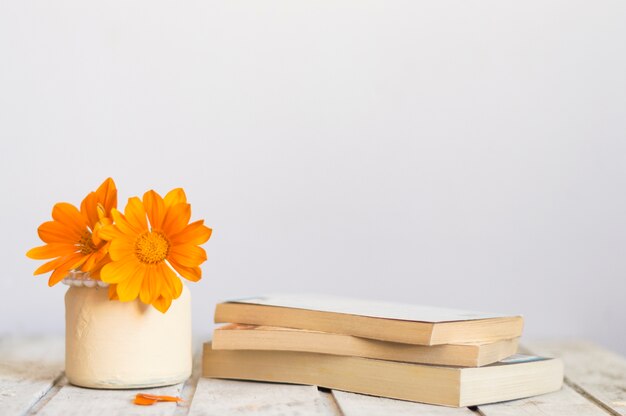 Wooden table with beautiful flowers and books