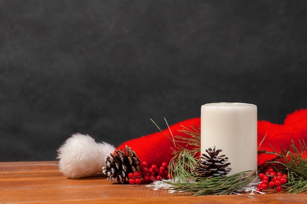 Free photo wooden table with christmas decorations and santa hat. christmas concept