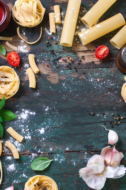 Wooden table with different types of pasta