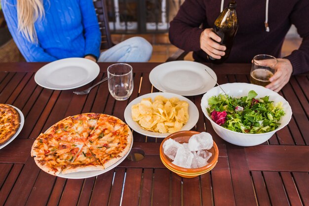 Wooden table with dishes and beer