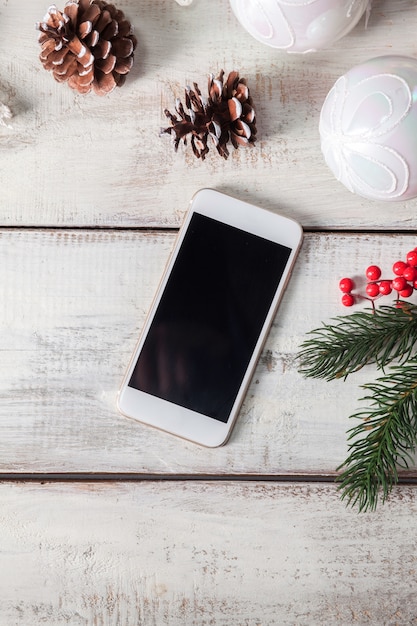 The wooden table with a phone and Christmas decorations.