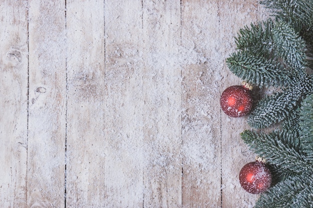 Wooden table with pine leaves and christmas balls