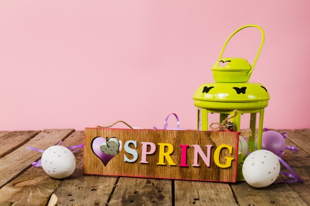 Wooden table with spring placard and easter eggs