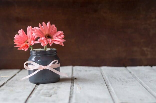 Wooden table with vase and cute flower