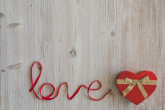 Wooden table with the word "love" and a box with heart shape